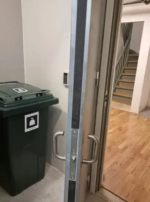 a door leading into a room with a trash can at Central Apartment for 4 in Trondheim