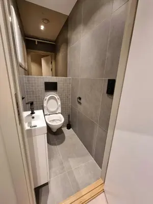 a small bathroom with a toilet and a sink at Central and Spacious Apartment for 8 in Trondheim