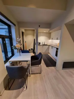 a kitchen and dining room with a table and chairs at Central and Spacious Apartment for 8 in Trondheim