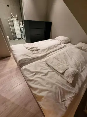 a large bed with white sheets and towels on it at Central Apartment for 2 in Trondheim