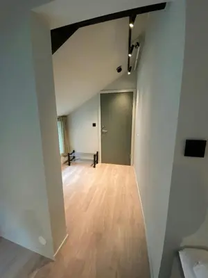 an empty room with white walls and a wooden floor at Central Apartment for 5 in Trondheim