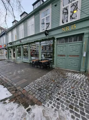 a green store front with a bench in front of it at Central Apartment for 5 in Trondheim