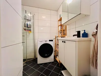 a small bathroom with a washing machine in it at Central apartment in Trondheim in Trondheim