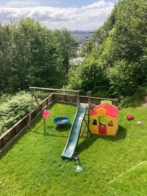 a playground with a slide in the grass at Duplex near airport in Bergen