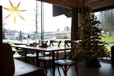 a table with a christmas tree in a restaurant at Elvehagen Hotell in Sande