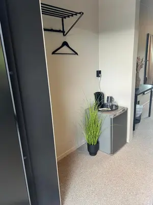 a mirror in a room with a table and a plant at Elvehagen Hotell in Sande