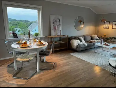 a living room with a table and a couch at Koselig leilighet med utsikt, gåavstand fra sentrum in Stord