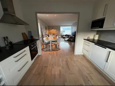 a kitchen with a table in the middle of a room at Koselig leilighet med utsikt, gåavstand fra sentrum in Stord