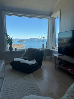 a living room with a couch and a large window at Koselig leilighet med utsikt, gåavstand fra sentrum in Stord