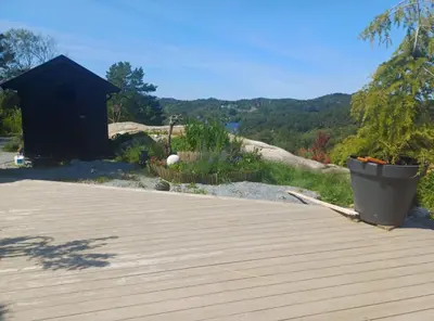 a wooden deck with a black shed in the background at Villa Varden 10 min from Bergen sentrum in Bergen