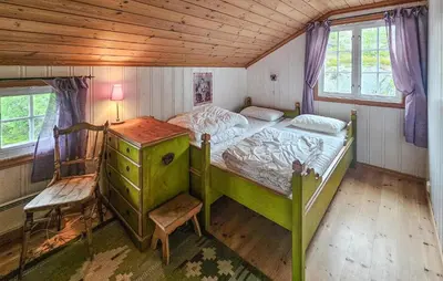 a bedroom with a green bed and a wooden ceiling at Amazing Home In Eggedal With Sauna in Eggedal