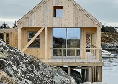 a wooden house on a dock in the water at Architectural Gem On Rocks In Kvenvær in Kvenvær