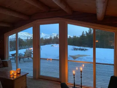 a screened in porch with a view of the snow at Log Cabin With Views Of Rondane Mountains in Folldal