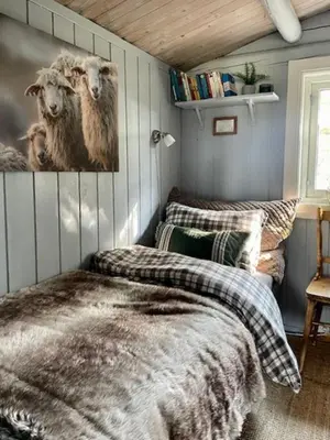 a bedroom with a bed and a picture of sheep at Log Cabin With Views Of Rondane Mountains in Folldal