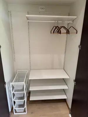 an empty closet with white shelves and white shelving at Living in a Nikolai Astrup motif 96m2 in Vassenden