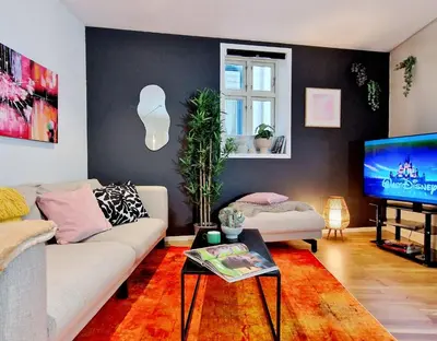 a living room with a couch and a tv at Prime location amazing king bed colorful oasis in Bergen