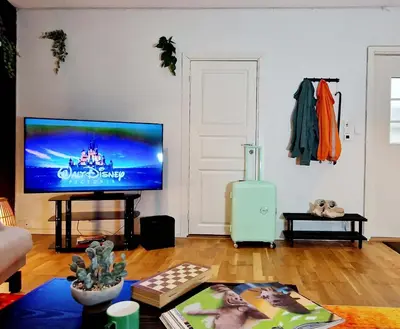 a living room with a flat screen tv on a wall at Prime location amazing king bed colorful oasis in Bergen