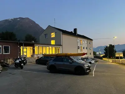 a car parked in a parking lot with a kayak on its roof at Åndalsnes House---Apartments in Åndalsnes
