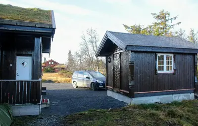 a car parked in a parking lot next to a building at Modern Family Cabin With Views Of Spåtind in Etnedal