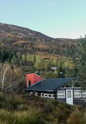 a red and white house on a hill at Mountain Cabin With Glacier Views in Norheimsund