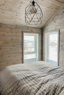 a bedroom with a bed and two windows at Mountain Cabin With Glacier Views in Norheimsund