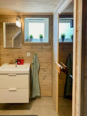 a bathroom with a sink and two windows at Mountain Cabin With Glacier Views in Norheimsund