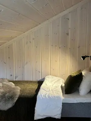 a bedroom with wooden walls and a bed with pillows at Magiske Vinterdage I Sjusjøen in Mesnali