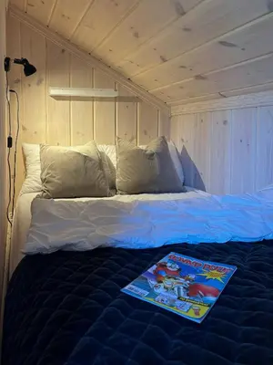 a bed with a book on it in a room at Magiske Vinterdage I Sjusjøen in Mesnali