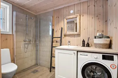 a bathroom with a washing machine and a shower at Magiske Vinterdage I Sjusjøen in Mesnali