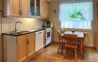 a kitchen with a sink and a table with chairs at Awesome Home In Åheim With Wifi in Åheim