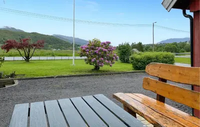 a wooden bench sitting next to a field with flowers at Awesome Home In Åheim With Wifi in Åheim