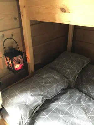 a bed in the corner of a room with a lamp at Stall Rygg Mountain Cottage, Gloppen