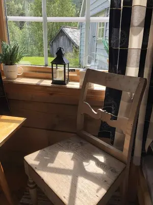 a wooden chair sitting in front of a window at Stall Rygg Mountain Cottage, Gloppen