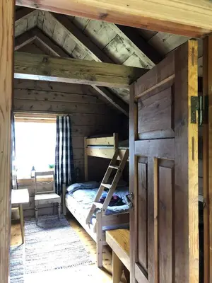 an attic room with a bunk bed and a ladder at Stall Rygg Mountain Cottage, Gloppen