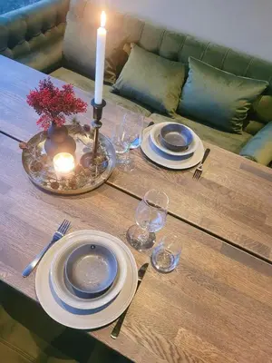 a table with a candle and plates and glasses on it at Modern Cabin At Blefjell in Svene