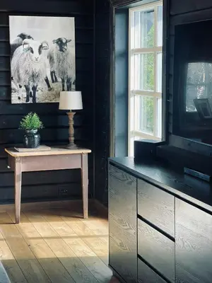 a room with a tv and a table with a picture of sheep at Spacious Family Cabin In Western Golsfjellet in Gol