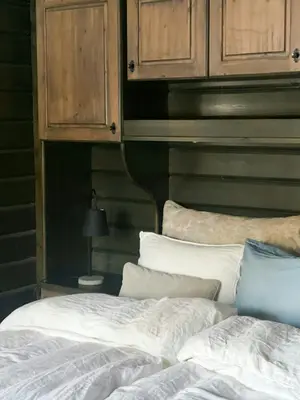 a bedroom with wooden cabinets and a bed with pillows at Spacious Family Cabin In Western Golsfjellet in Gol