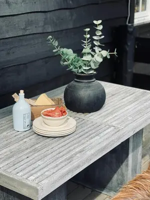 a black vase sitting on a table with a plate at Spacious Family Cabin In Western Golsfjellet in Gol