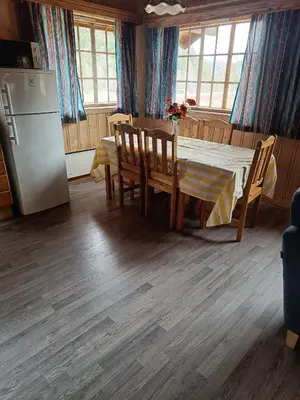 a kitchen with a dining room table and a refrigerator at Stavn gård og hytter- 8 minutter til Bjørneparken in Flå