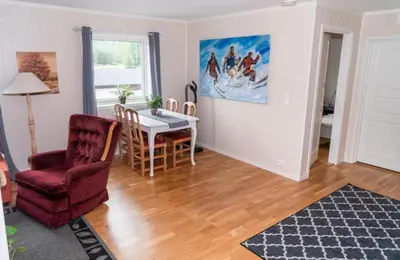 a living room with a table and a chair at Signegarden in Skjåk