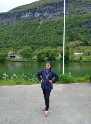 a woman standing in front of a body of water at Stryn Norway in Stryn