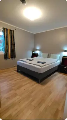 a large bed in a room with a wooden floor at Stryn Norway in Stryn