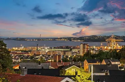 a view of a city with a harbor at dusk at Leilighet nær Color Line i Larvik in Lii