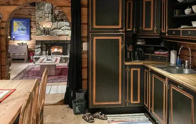 a kitchen with wooden cabinets and a fireplace in a cabin at 4 Bedroom Gorgeous Home In Hovden I Setesdal in Hovden