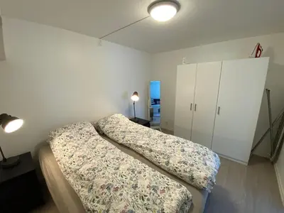 a bedroom with two beds and a white cabinet at Kozy apartment near Bergen city center with free parking and Wifi in Bergen