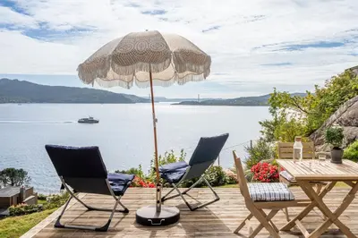 a patio with an umbrella and two chairs and a table at Panoramic view with private terrace in Bergen