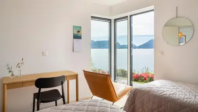 a bedroom with a desk and a bed and a table and chair at Panoramic view with private terrace in Bergen
