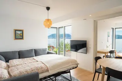 a bedroom with a bed and a dining room with a table at Panoramic view with private terrace in Bergen