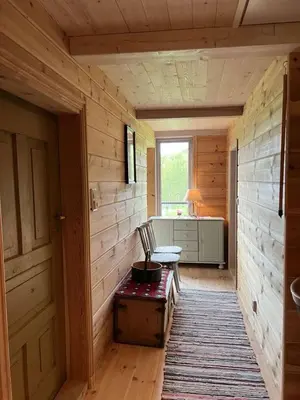 a hallway of a wooden cabin with a bench and a window at Gamlestova in Viksdalen