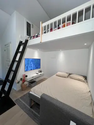 a bedroom with a bunk bed and a ladder at Cozy and modern studio house in Trondheim